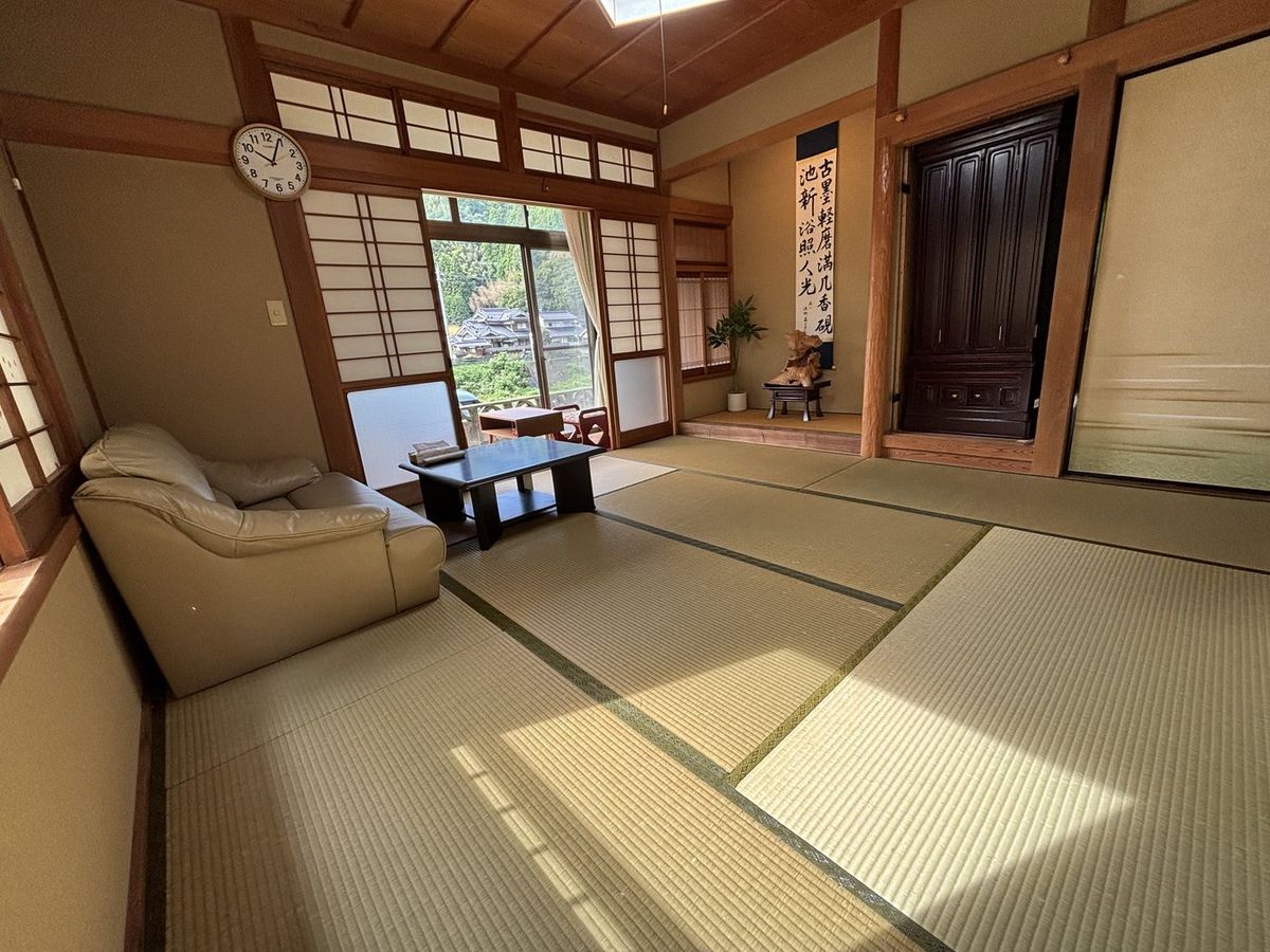 1階の和室。床の間と掛け軸、ソファと座卓のあるリビング